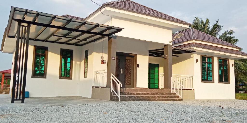 una casa blanca con pérgola en Homestay Asam Pedas Parit Jawa Muar, en Bakar Parit
