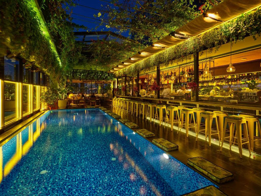 una piscina con sillas y un bar en The Smallville Hotel, en Beirut