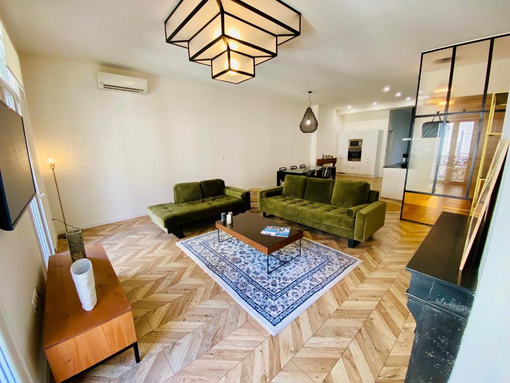 - un salon avec deux canapés verts et une table dans l'établissement ''Rousseau'' Superbe T2 climatisé au Théâtre Molière, à Sète