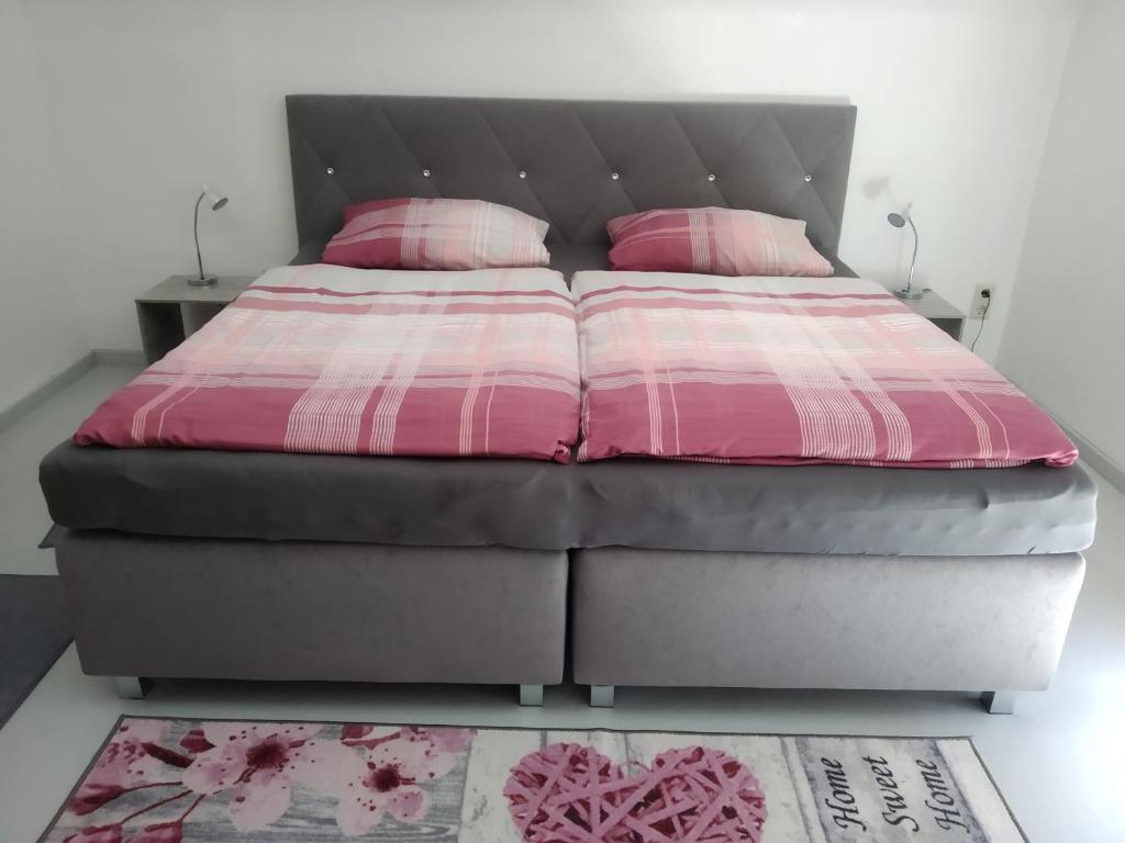 een bed met roze en witte lakens en roze kussens bij Ferienwohnung Sonnenblick in Oberharmersbach