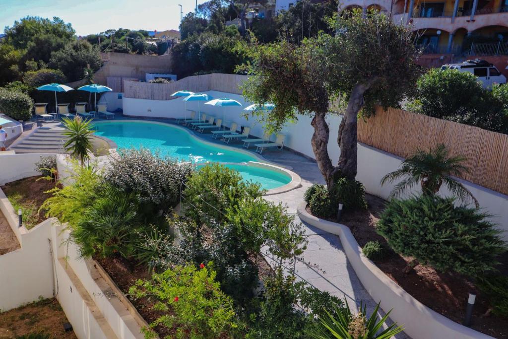 - une piscine dans un complexe avec des arbres et des buissons dans l'établissement Best Western Hotel Blumarea, à Castelsardo