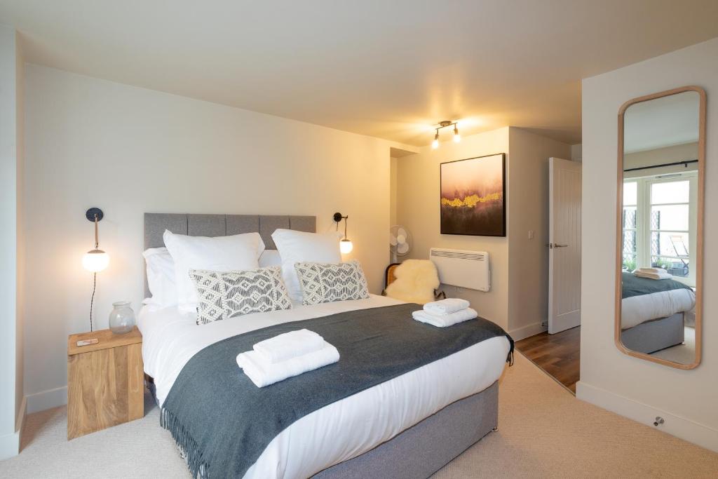 una camera con un grande letto e uno specchio di 30 Chipping Norton - Luxury Holiday Apartments a Chipping Norton