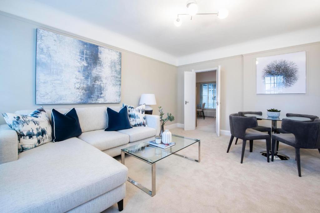 a living room with a couch and a table at Chelsea Pelham Apartments in London