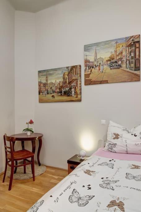 a bedroom with a bed and a table with a chair at City and Calmness in Budapest