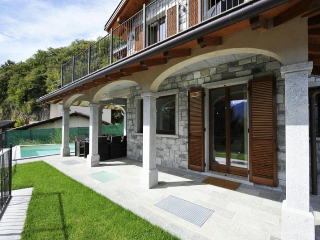 een huis met een patio en een zwembad bij Villa Lumbini in Plesio