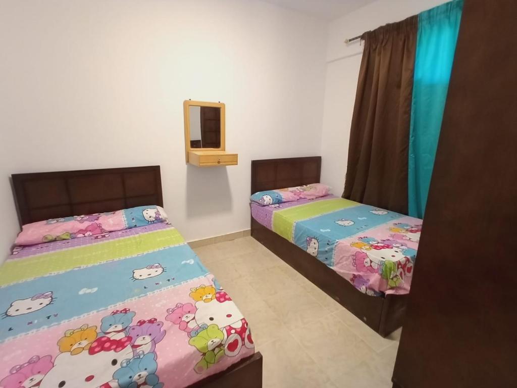 um quarto com 2 camas e uma televisão em قرية بلو لاجون راس سدر em Ras Sedr
