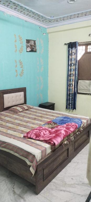 a bedroom with a large bed with blue walls at Mostel hotel in Jaipur