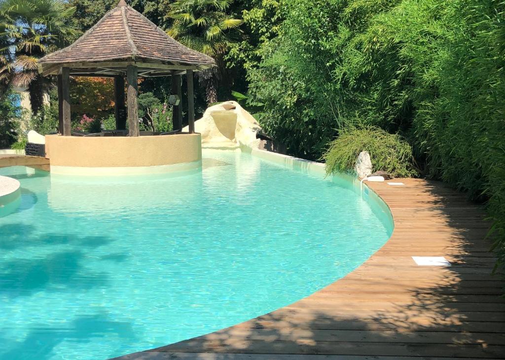 a swimming pool with a gazebo in a garden at Gite l’Oasis in Astaffort