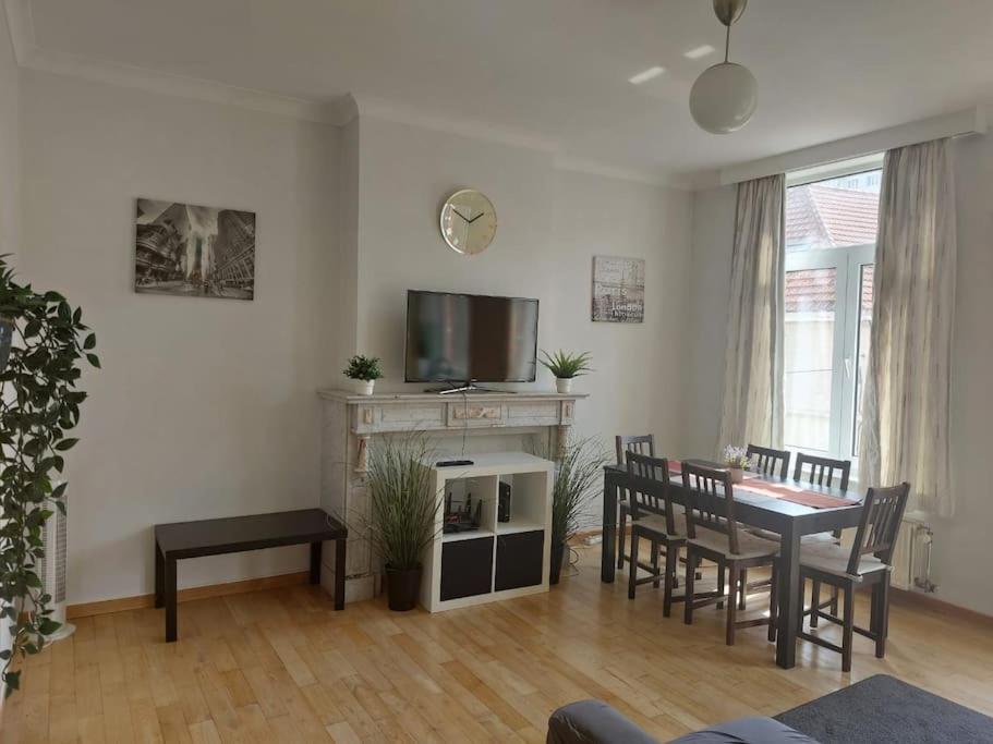 - un salon avec une table, des chaises et une télévision dans l'établissement Charming 1-Bedroom Apartment, à Bruxelles