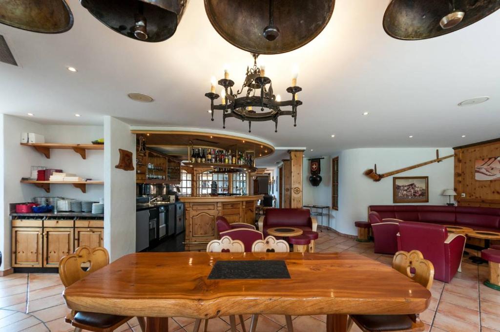 a dining room and kitchen with a table and chairs at Alpe Fleurie Hôtel & Restaurant in Villars-sur-Ollon