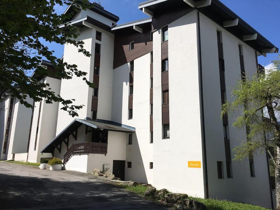 a large white building with a staircase in front of it at Studio très lumineux 4 pers in Les Carroz d'Araches
