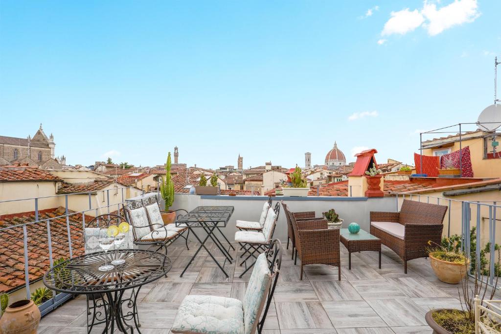 a patio with chairs and tables on a roof at Dante - Sweet Dreams in Florence in Florence