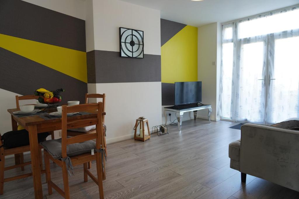 a living room with a table and a tv at Our 2 bedroom house or borders of Bromley and Lewisham is available now! in Catford