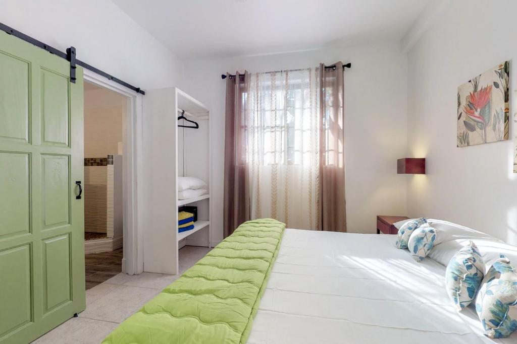 ein Schlafzimmer mit einem Bett mit einer grünen Tür in der Unterkunft Casa DV Suites Gold Standard Certified in Caye Caulker