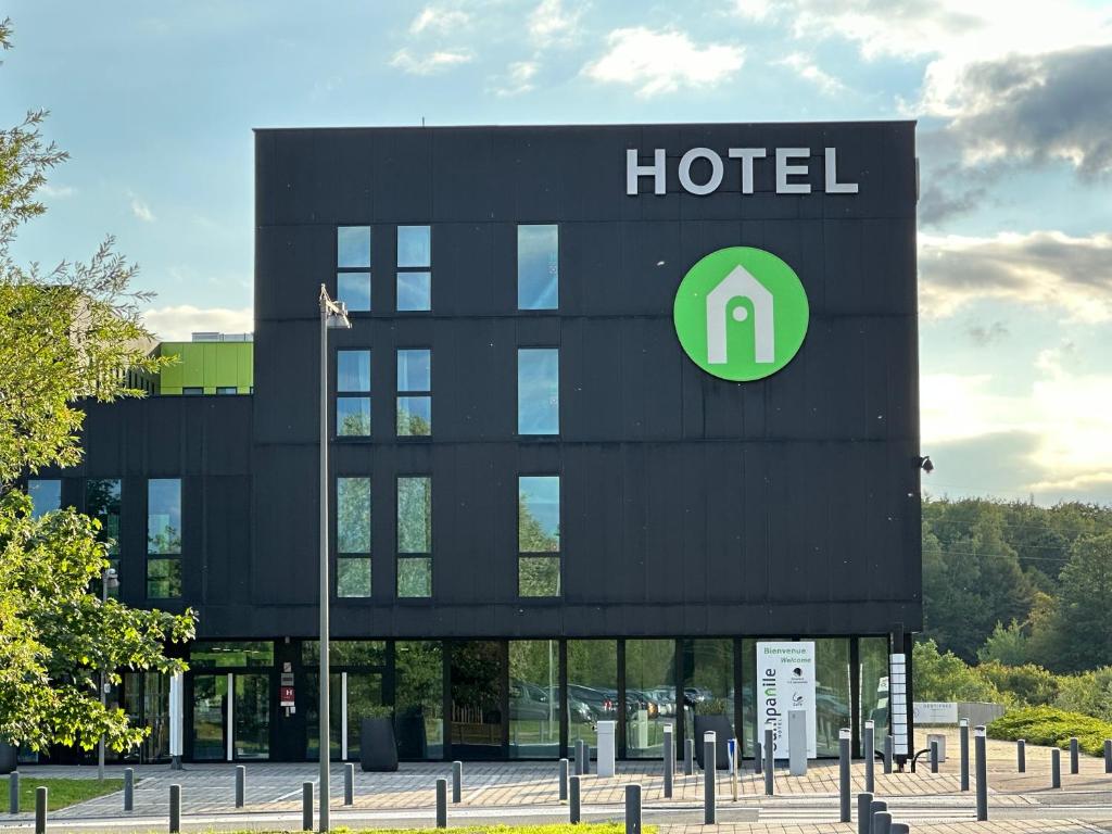 una señal de hotel frente a un edificio en Campanile Belfort Montbéliard - Gare La Jonxion., en Meroux