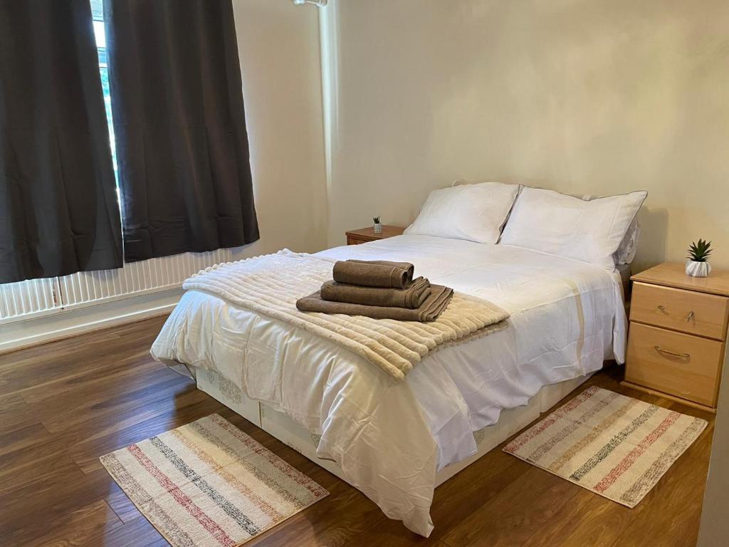 a bedroom with a bed with two towels on it at Single and doubles rooms close to central London in London