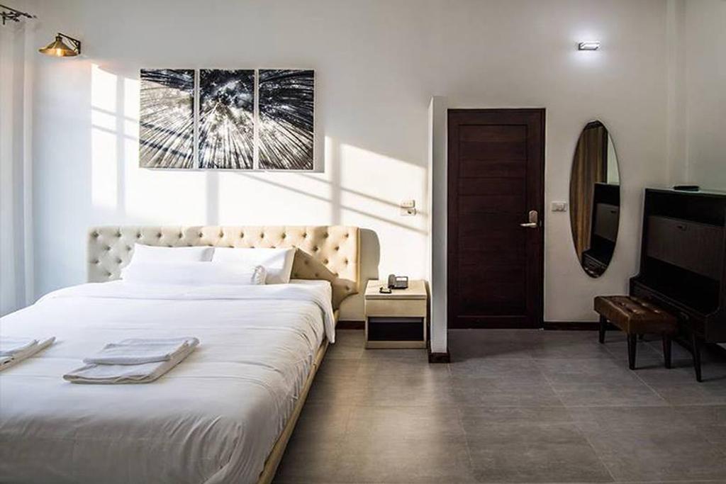 a bedroom with a large bed and a television at Na Klongluang Boutique Resort in Ban Khlong Nung