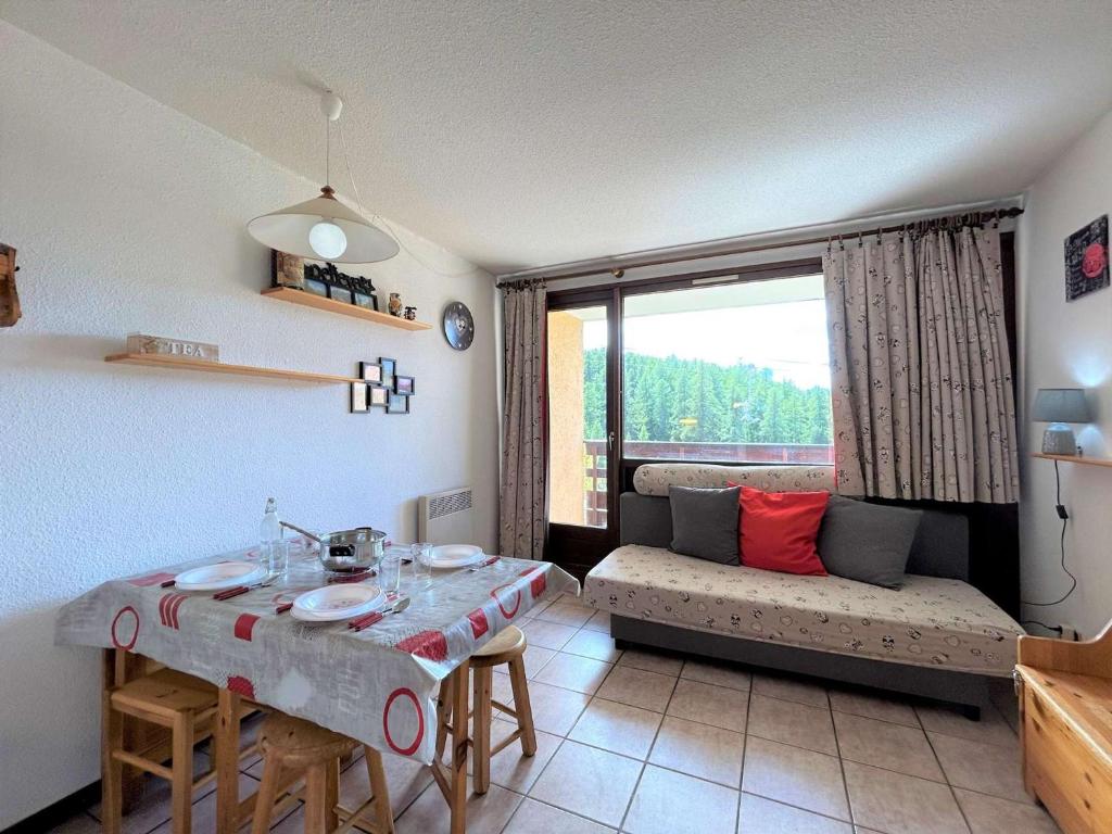 ein Wohnzimmer mit einem Tisch und einem Sofa in der Unterkunft Appartement Montgenèvre, 2 pièces, 6 personnes - FR-1-330D-70 in Montgenèvre