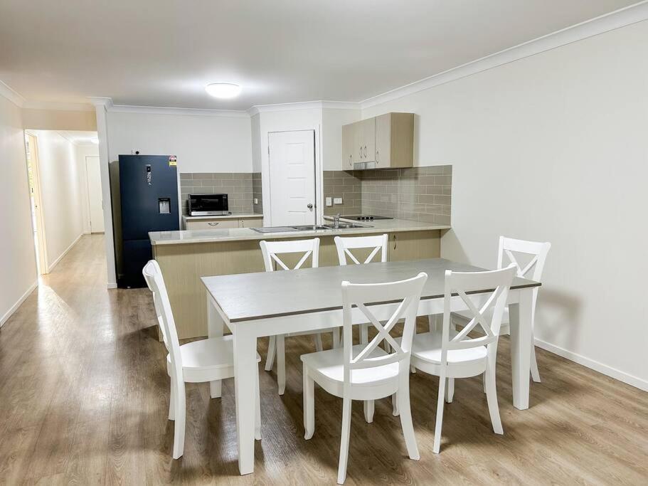 a kitchen with a white table and white chairs at Stay at Mandi’s in Kingston