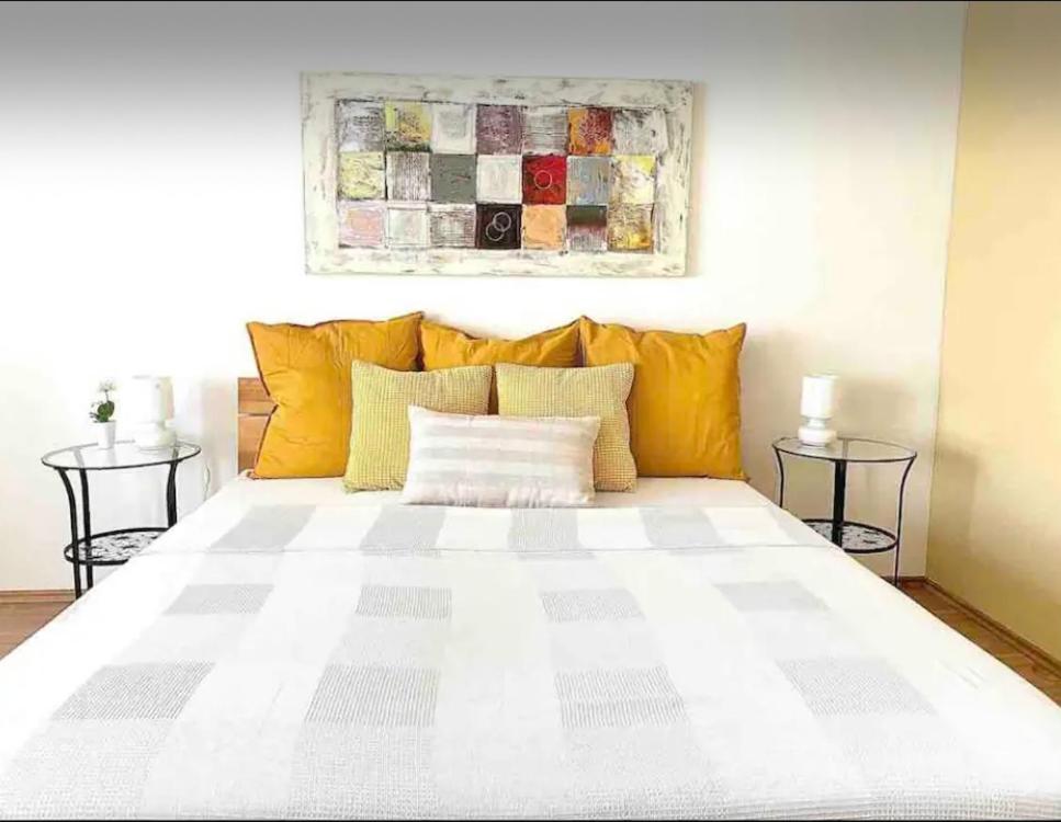 a bedroom with a white bed with yellow pillows at Studio next to Karlsplatz/Karlskirche in Vienna
