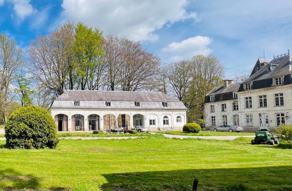 Chateau d'Humieres holiday cottage في Humières: بيت ابيض كبير على ارض خضراء