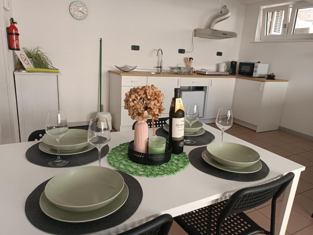 einen Tisch mit Tellern und Gläsern sowie eine Flasche Wein in der Unterkunft Apartma 31 in Nova Gorica