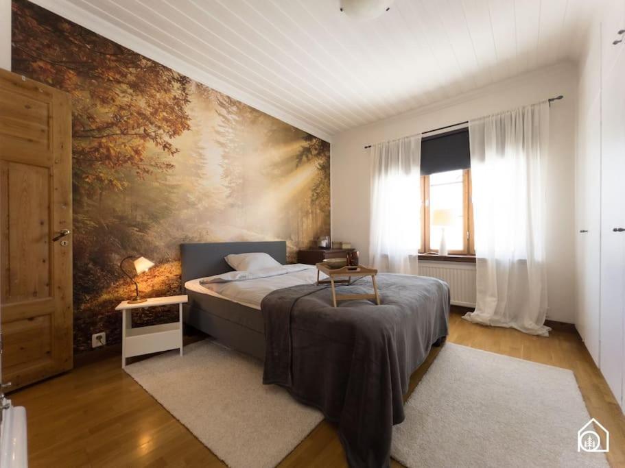 ein Schlafzimmer mit einem Bett und einem Wandgemälde in der Unterkunft Rustic Villa in Central Piteå in Piteå