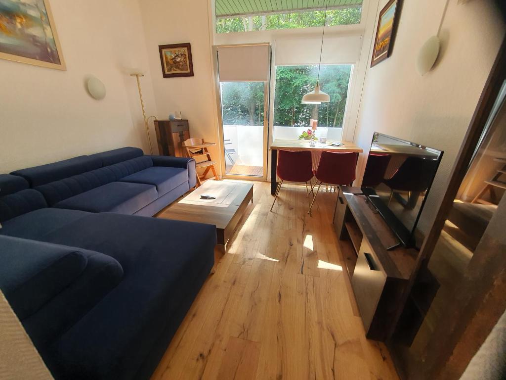 uma sala de estar com um sofá azul e uma mesa em Happy Home - inclusive Pool & Sauna em Bad Harzburg