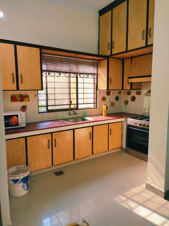 a kitchen with wooden cabinets and a sink at 2 bedrooms house for families in Lahore