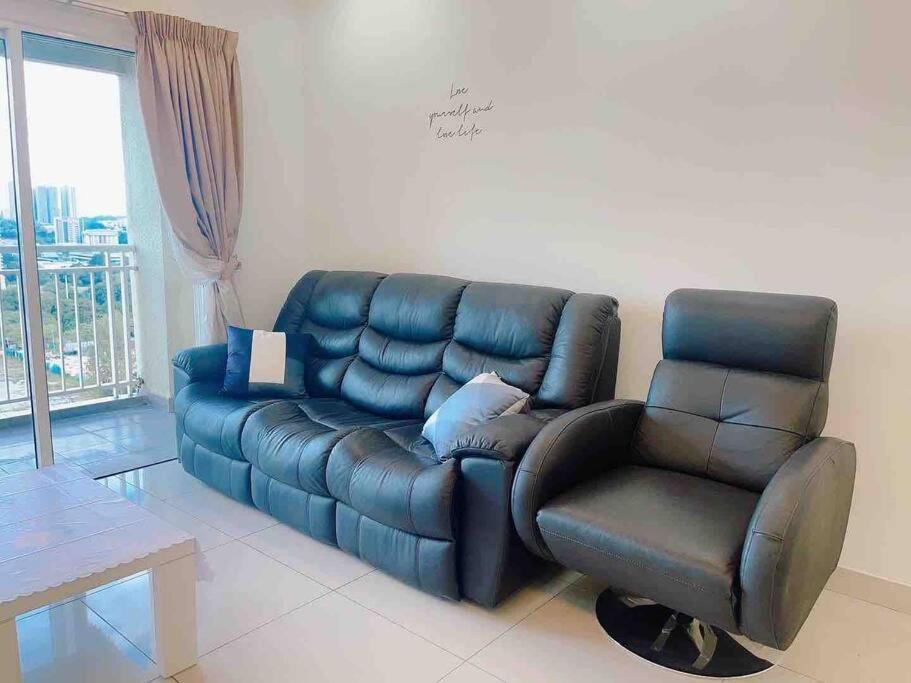 a living room with a leather couch and a chair at Big Happy Family @ Sri Petaling/Axiata Stadium in Kuala Lumpur