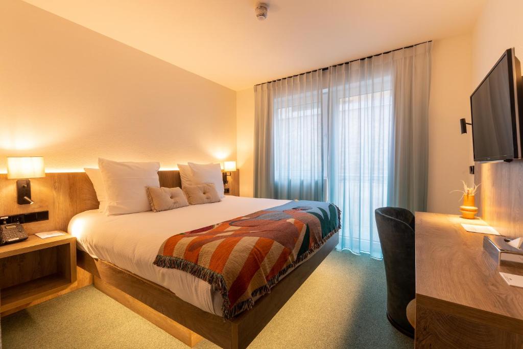 a hotel room with a bed and a television at Kazakiwi in Luxembourg