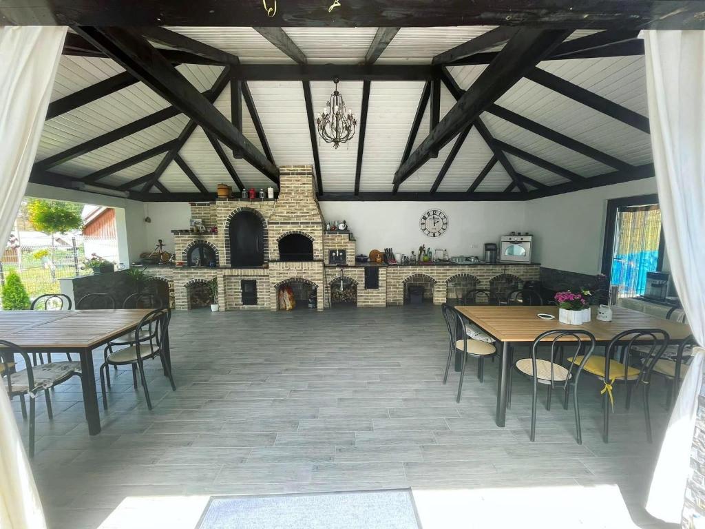 Habitación con mesas, sillas y chimenea. en Bucovina Inn en Voronet