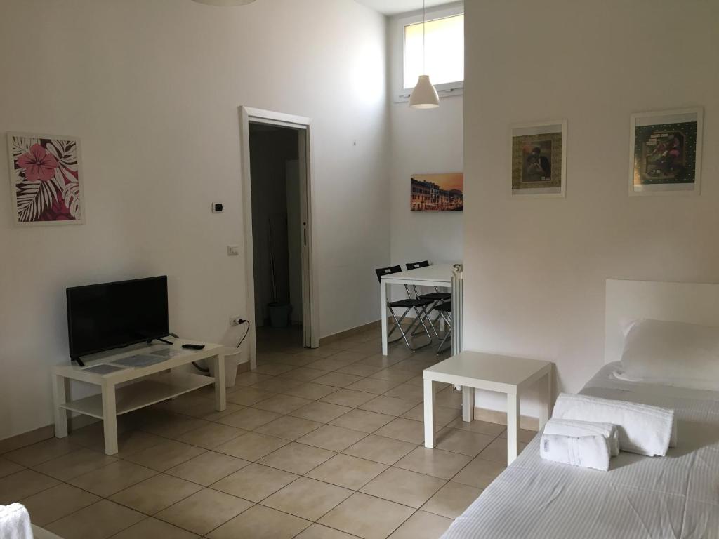 een woonkamer met 2 bedden en een televisie bij Affittacamere Italia Leonardo in Rho