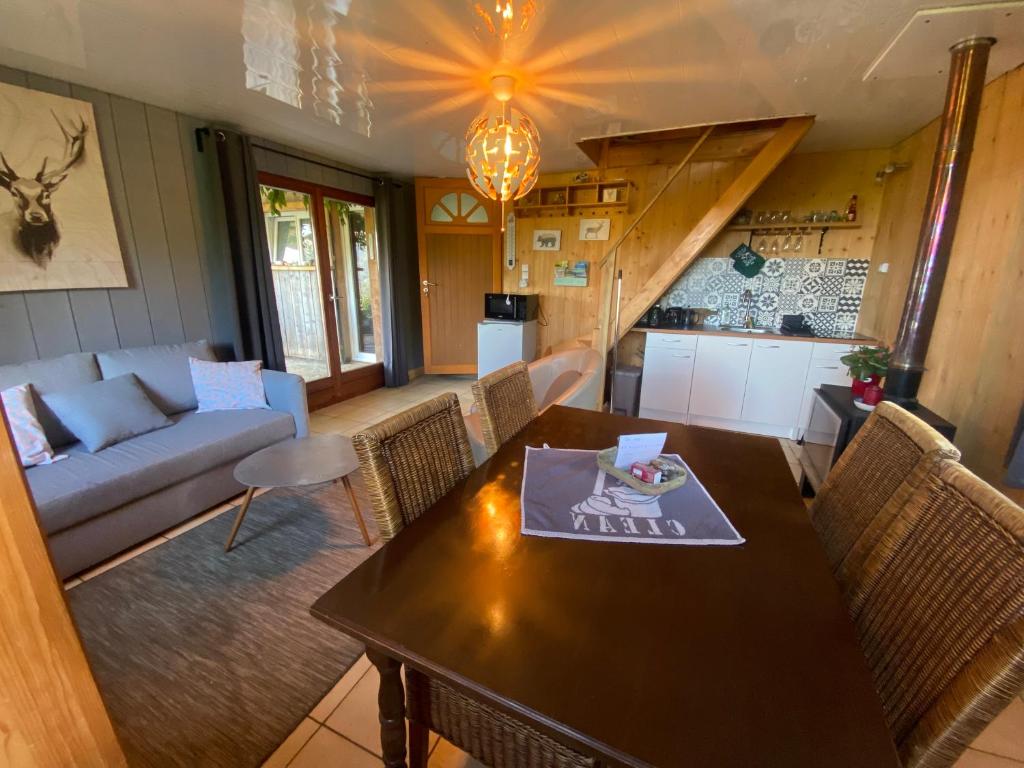 ein Wohnzimmer mit einem Tisch und einem Sofa in der Unterkunft Gîte Croc Blanc in Sondernach