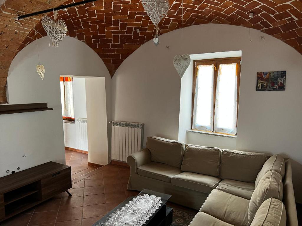 - un salon avec un canapé et un mur en briques dans l'établissement Il BORGHETTO-1, à Grazzano Badoglio