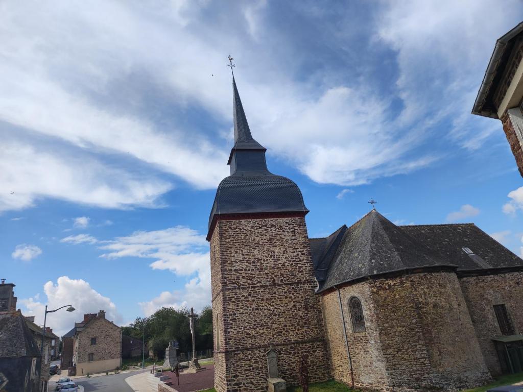 una vieja iglesia con un campanario en una calle en Ty Ker Spa Brocéliande, en Saint-Malon-sur-Mel