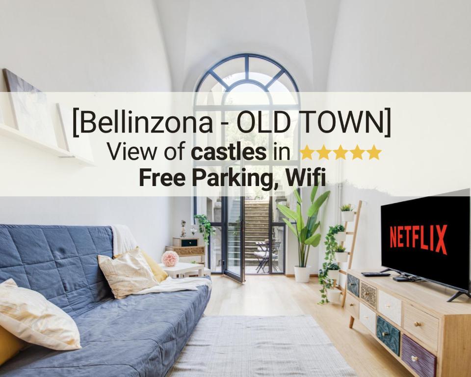 un soggiorno con divano blu e TV di [Bellinzona-Centro Storico] Vista castelli a ☆☆☆☆☆ a Bellinzona