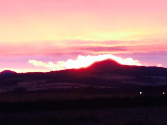 a sunset over a field with a mountain in the background at Star Scape in Markinch