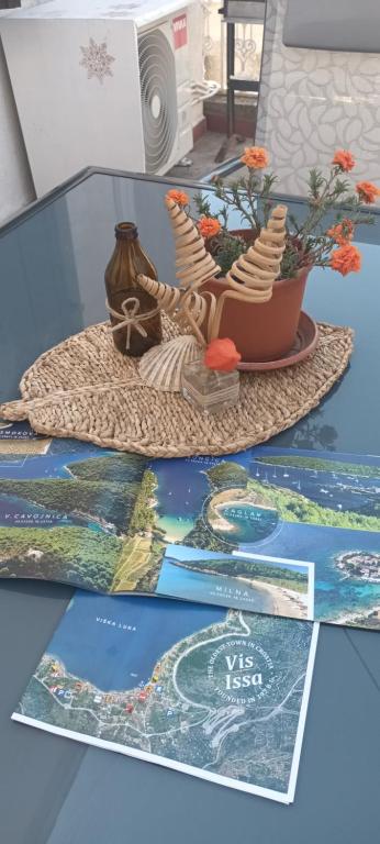 einen Tisch mit einer Zeitschrift und eine Vase mit einem Boot darauf in der Unterkunft Nona Ružica in Vis