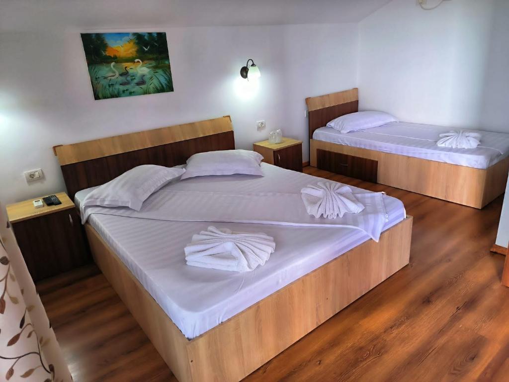 two beds in a room with wooden floors at Casa Maruska in Murighiol