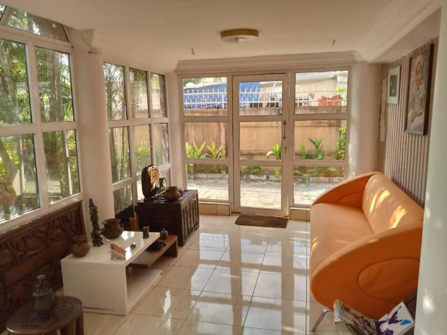 uma sala de estar com um sofá e janelas grandes em 1-bedroom apartment in dolphin em Lagos