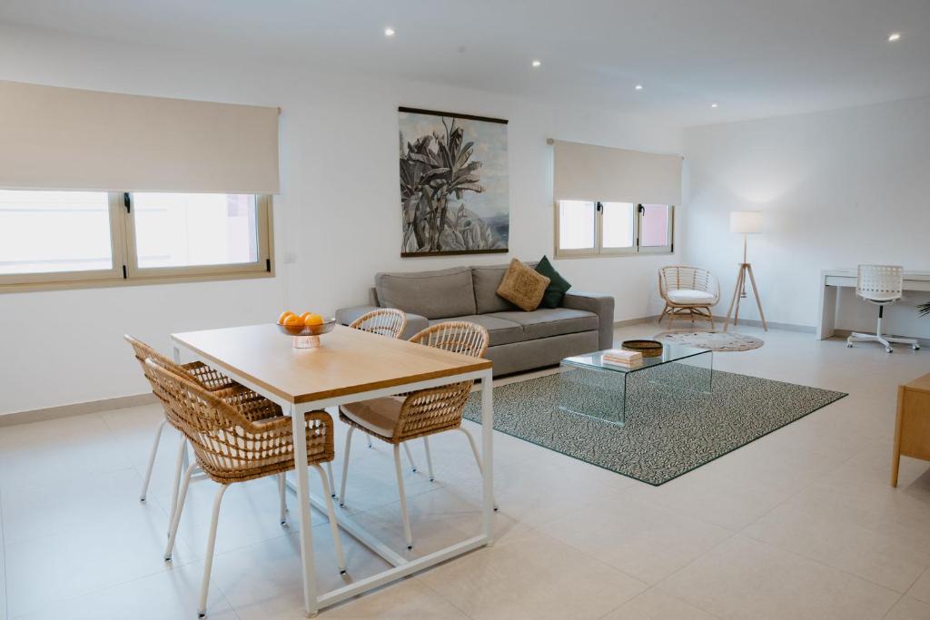 ein Wohnzimmer mit einem Tisch und einem Sofa in der Unterkunft Las Canteras Beach Suites in Las Palmas de Gran Canaria