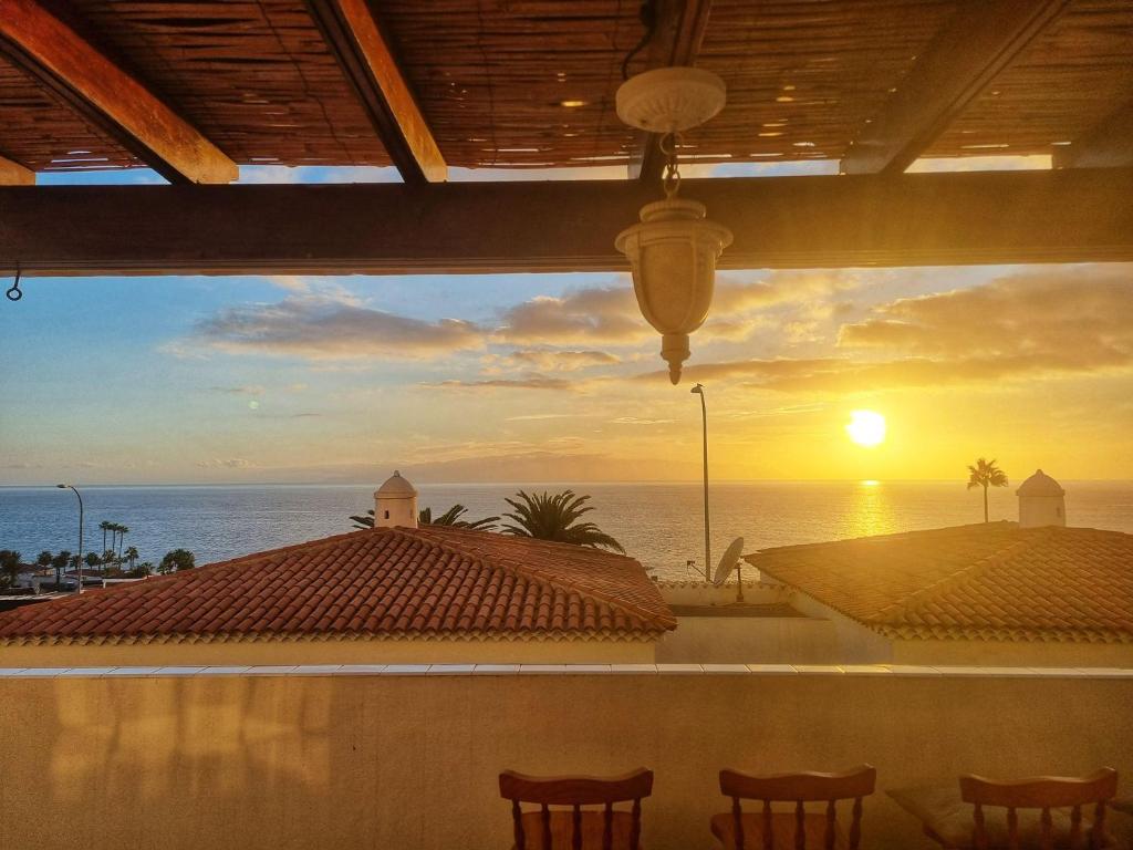 uma vista para o oceano a partir de um resort com um pôr-do-sol em Puertito Varadero em Puerto de Santiago
