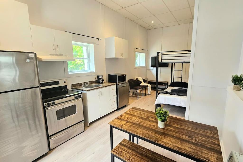 une cuisine avec des appareils en acier inoxydable et un salon dans l'établissement WOW - Loft Vieux-Limoilou à proximité Vieux-QC!, à Québec