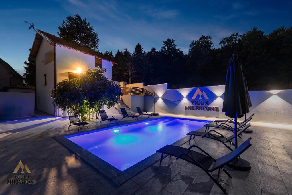 a swimming pool in front of a house at night at Villa Milestone Majevica 