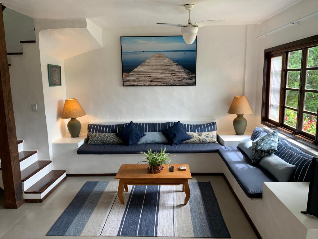 sala de estar con sofá azul y mesa en Buzios, Amazing Location, Fully Equipped, Great Pool!, en Búzios