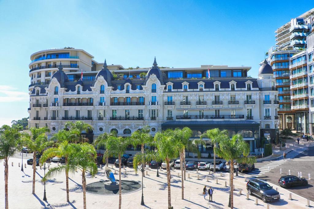 a large building with palm trees in front of it at Hôtel de Paris Monte-Carlo in Monte Carlo