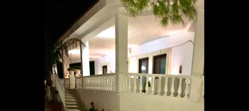 Biały dom z białą poręczą i schodami w obiekcie A CASA NOSCIA - BB SAN PIETRO IN BEVAGNA Charming house w mieście San Pietro in Bevagna