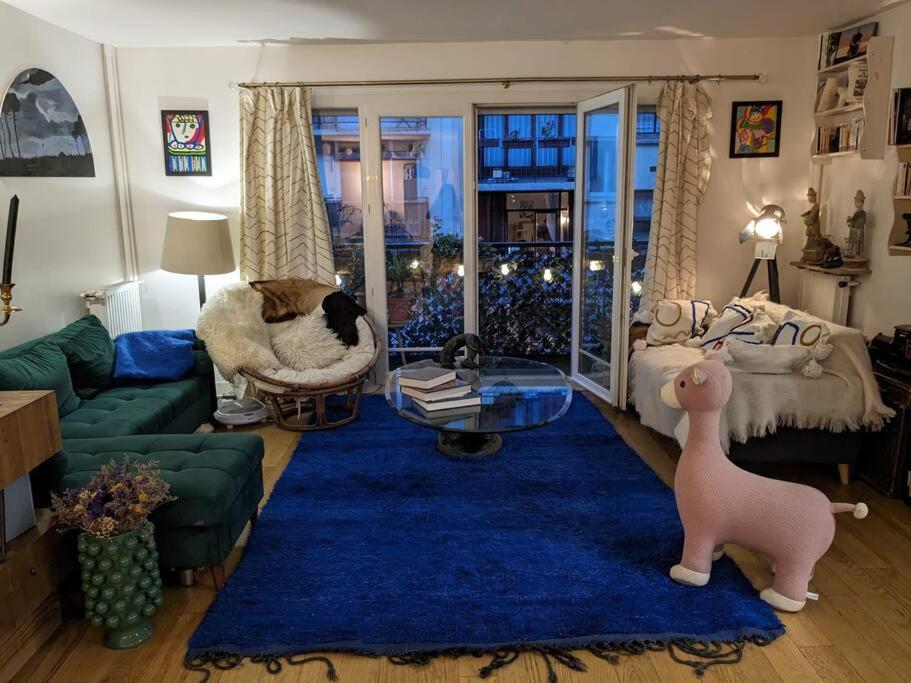 a living room with a couch and a blue rug at Appartement avec balcon proche de Montmartre in Paris