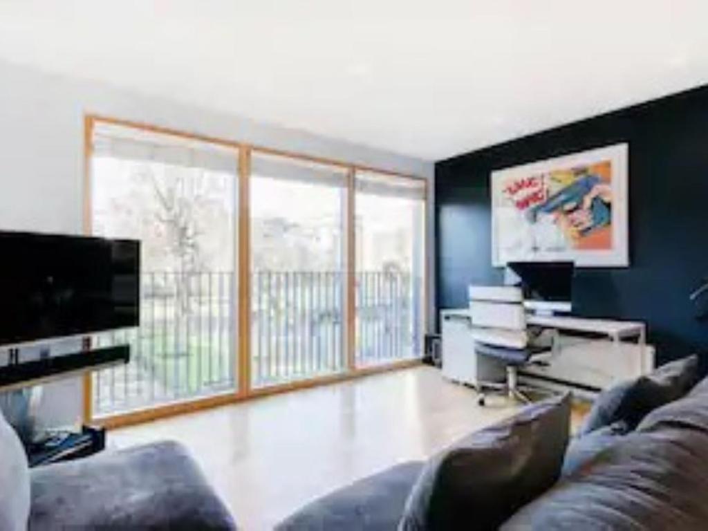 uma sala de estar com um sofá e uma grande janela em Pass the Keys Boutique London Flat near Tower Bridge and Tube em Londres